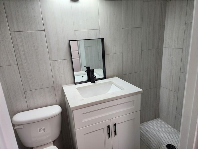 bathroom featuring toilet, walk in shower, and vanity