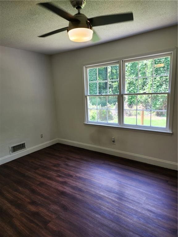 unfurnished room featuring ceiling fan, dark hardwood / wood-style floors, and a textured ceiling