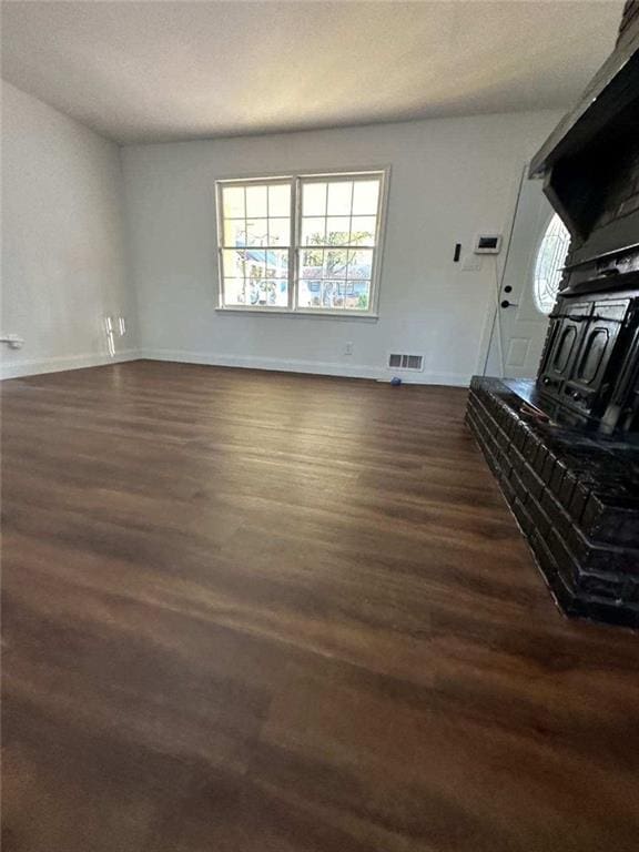 unfurnished living room featuring dark wood-type flooring