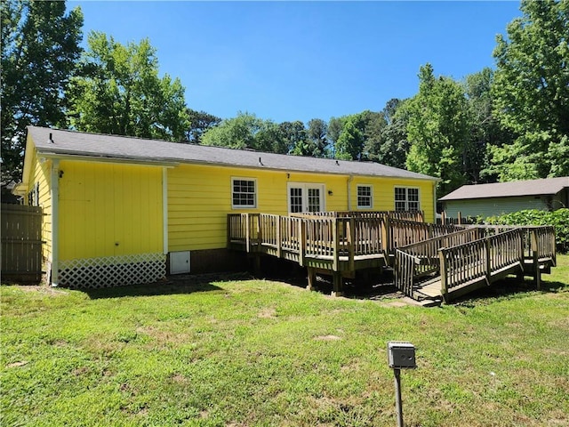 rear view of house featuring a deck and a lawn