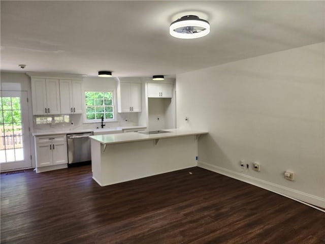 kitchen featuring dishwasher, dark hardwood / wood-style floors, black electric cooktop, white cabinets, and a kitchen breakfast bar