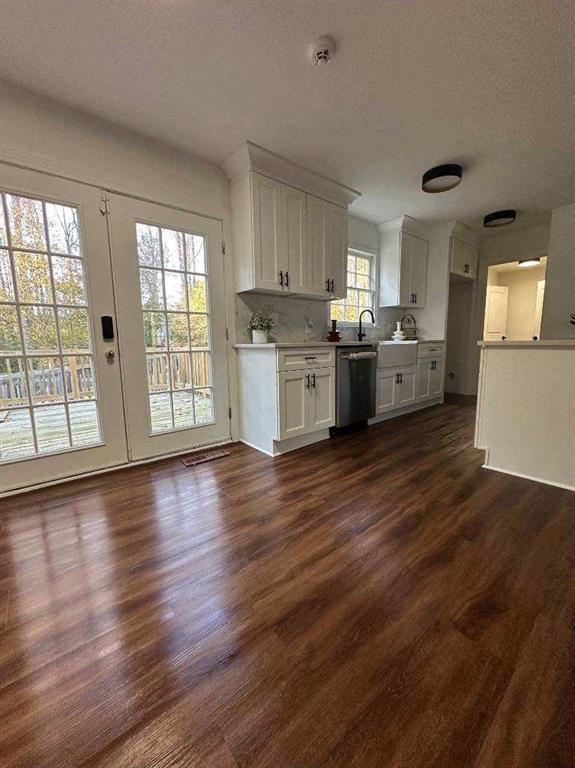 kitchen with white cabinets, a textured ceiling, dishwasher, and dark hardwood / wood-style floors