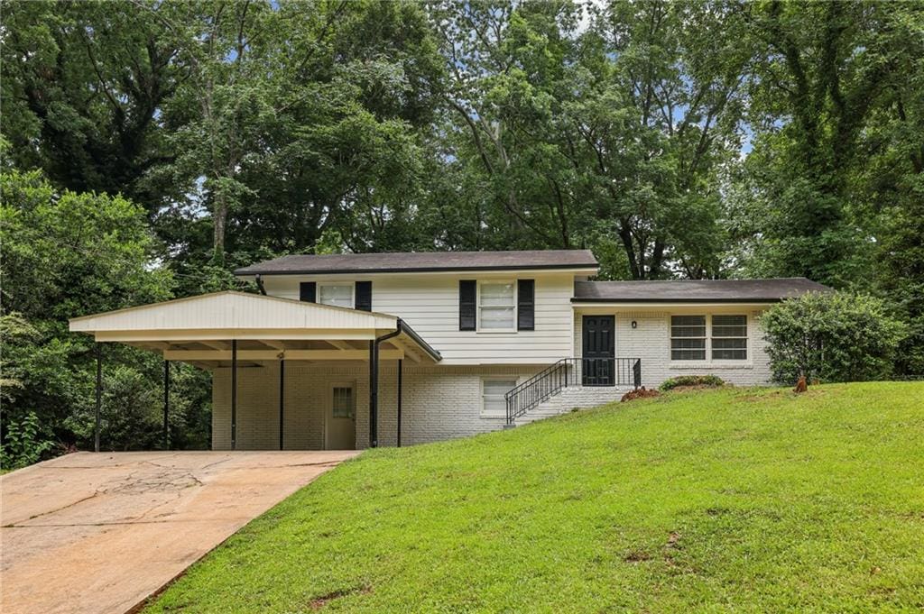 view of front of property with a front lawn and a carport