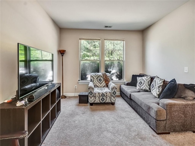 living area featuring baseboards, visible vents, and carpet floors