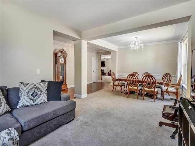 living room featuring carpet, a notable chandelier, and ornamental molding