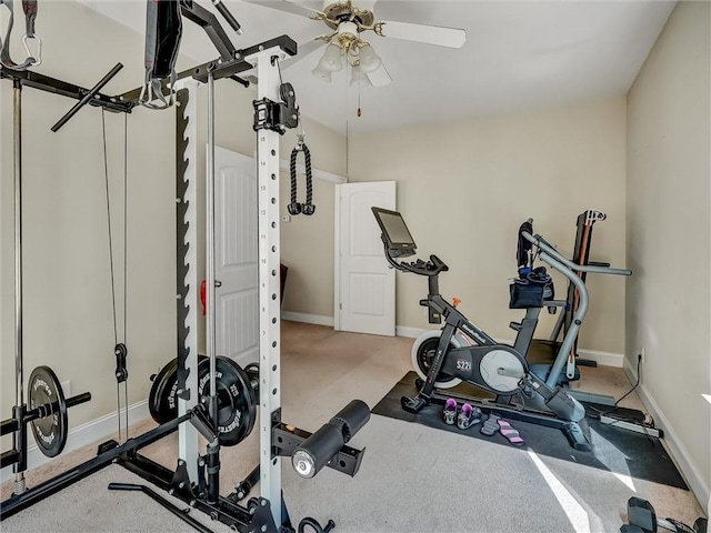 workout room with baseboards and a ceiling fan