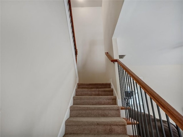 staircase featuring baseboards and visible vents