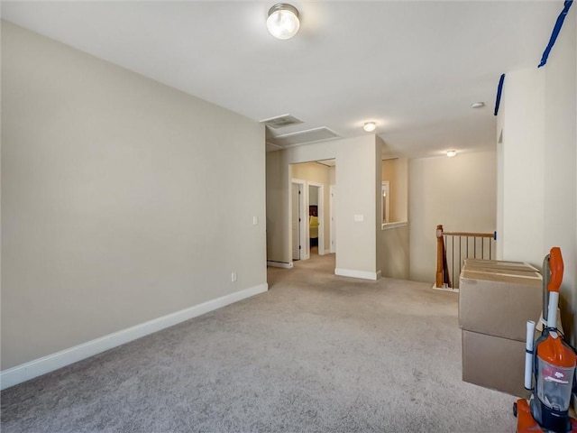 empty room with attic access, baseboards, visible vents, and carpet