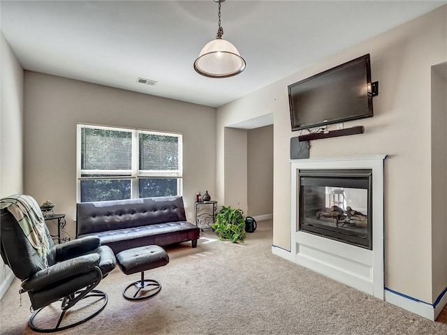 carpeted living area featuring baseboards, visible vents, and a multi sided fireplace