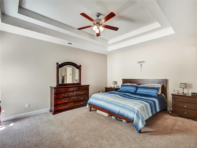 bedroom with baseboards, carpet flooring, a tray ceiling, and visible vents