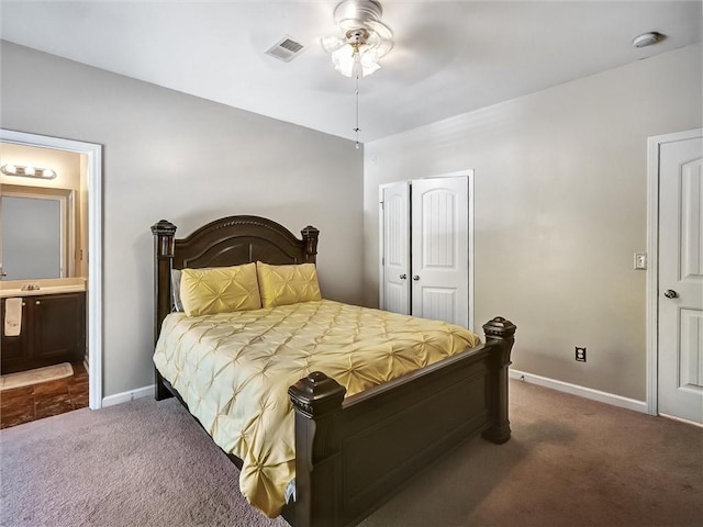 carpeted bedroom featuring baseboards, ensuite bath, visible vents, and a closet