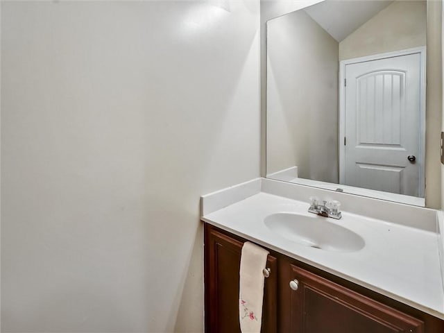 bathroom with lofted ceiling and vanity