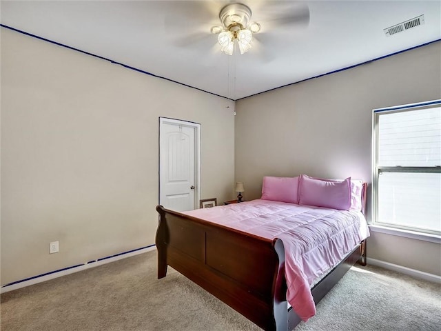 carpeted bedroom with visible vents, a ceiling fan, and baseboards
