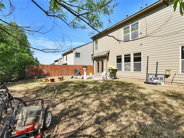 rear view of property with a lawn and fence