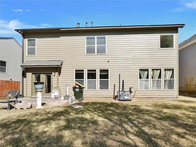 back of house featuring fence, a lawn, and a patio