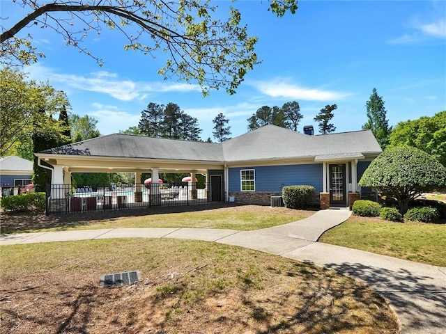 view of front of property with fence, a front lawn, and central AC unit