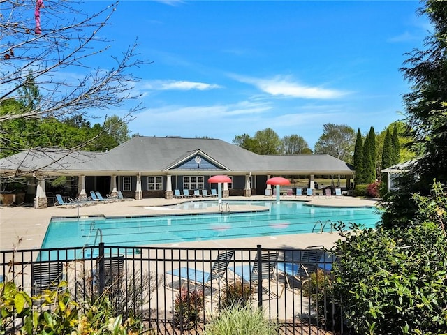 community pool with fence and a patio