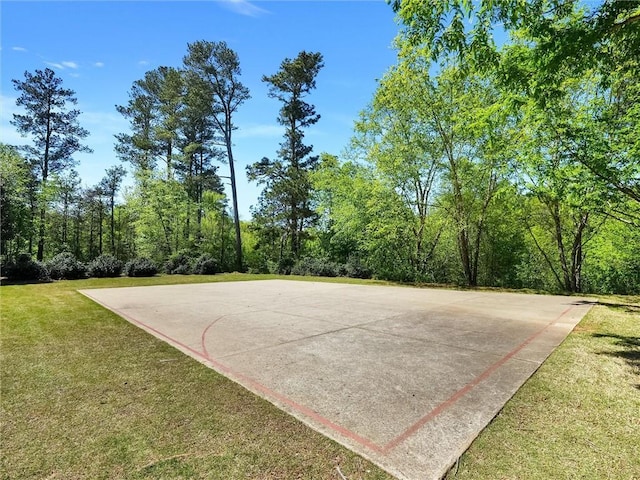 view of basketball court featuring basketball court and a lawn