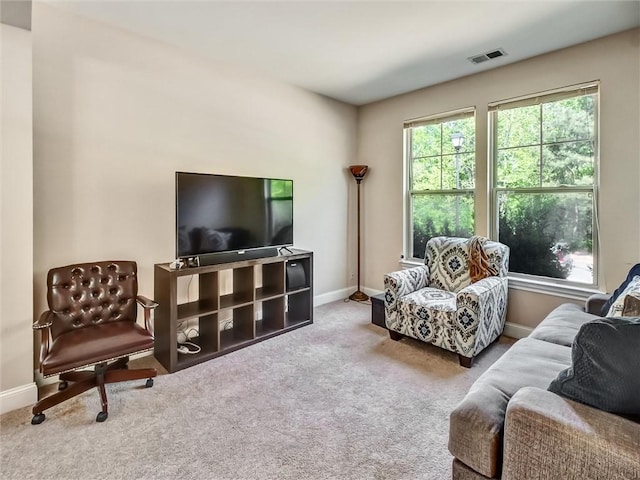 living room with baseboards, visible vents, and carpet