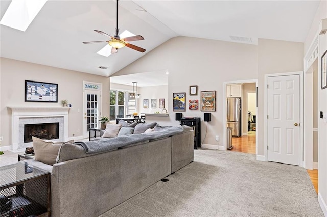 3072 Oaktree Ln, Duluth, GA 30096 - living area featuring high vaulted ceiling, light colored carpet, a ceiling fan, a premium fireplace, and a skylight