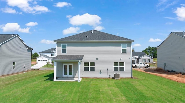 back of property with french doors, a yard, and central air condition unit