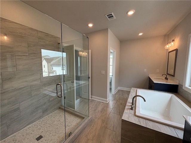 173 Basil St, Cumming, GA 30040 - full bathroom with a stall shower, vanity, a bath, recessed lighting, and baseboards