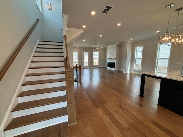 173 Basil St, Cumming, GA 30040 - stairs with crown molding, healthy amount of natural light, a chandelier, wood finished floors, and recessed lighting