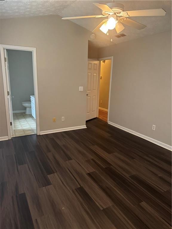 spare room featuring baseboards, dark wood-type flooring, and a ceiling fan