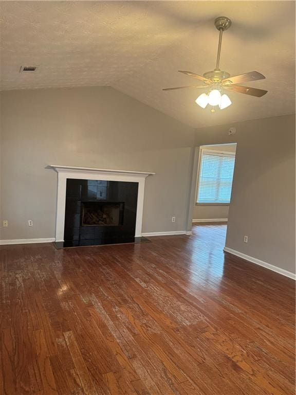 unfurnished living room with visible vents, wood finished floors, a ceiling fan, and vaulted ceiling