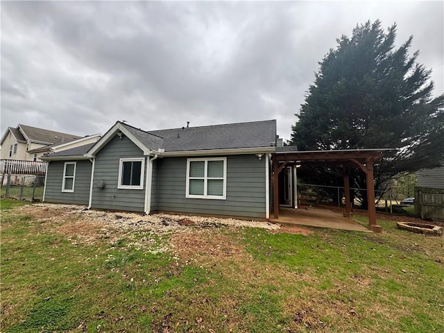 rear view of house with a patio, a lawn, a pergola, and fence