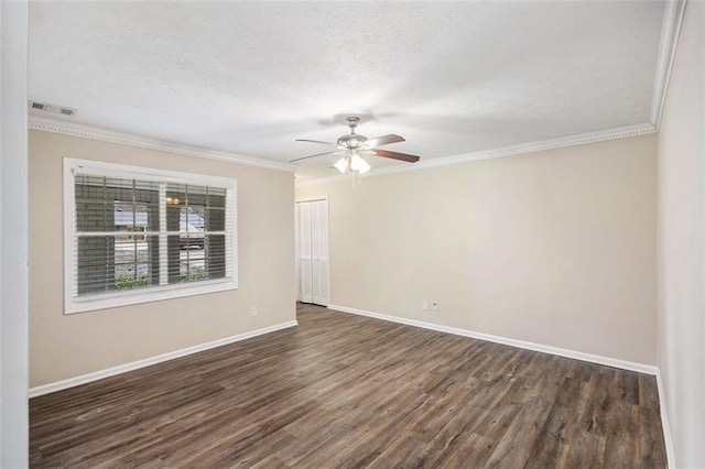 spare room with crown molding, baseboards, dark wood-style flooring, and a textured ceiling