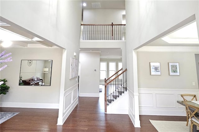 foyer entrance with dark hardwood / wood-style flooring and ornamental molding