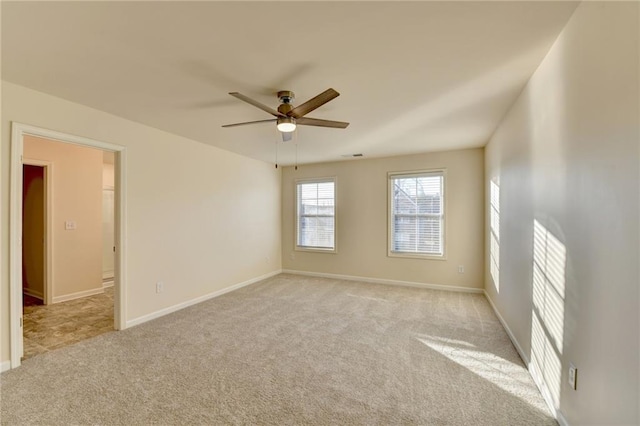 unfurnished room with baseboards, a ceiling fan, and light colored carpet