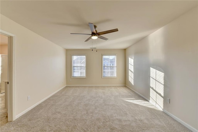 empty room with baseboards, a ceiling fan, and light colored carpet