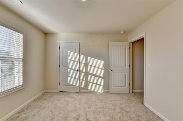 unfurnished room featuring carpet flooring and baseboards