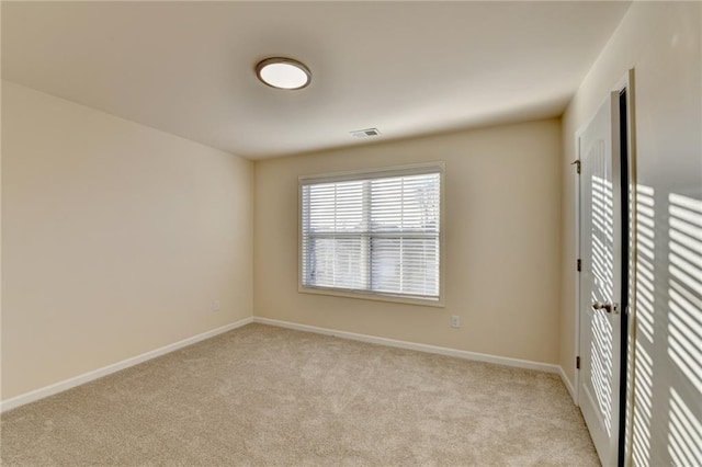 empty room featuring light carpet, visible vents, and baseboards