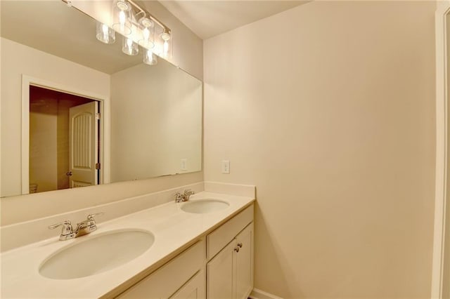 bathroom featuring a sink, baseboards, and double vanity