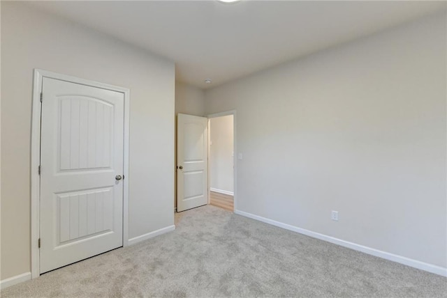 unfurnished bedroom featuring carpet floors and baseboards