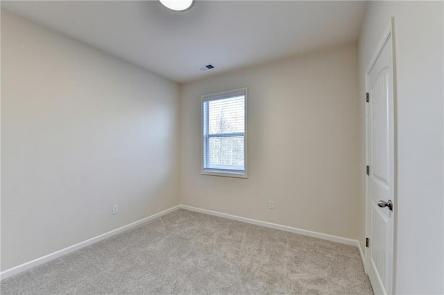 unfurnished room with visible vents, light carpet, and baseboards