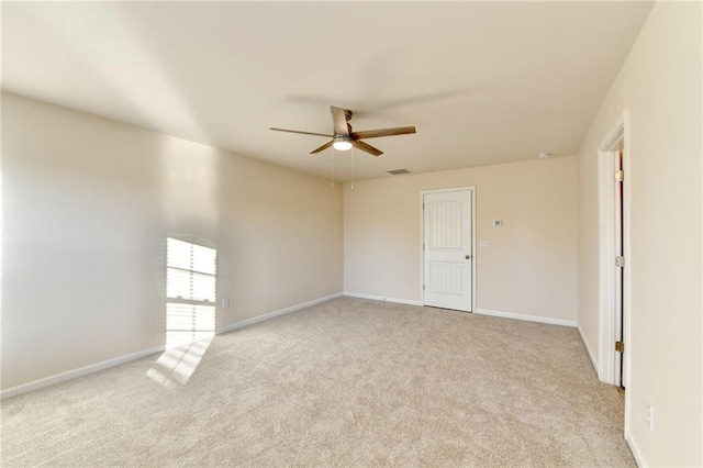 spare room featuring light carpet, baseboards, visible vents, and ceiling fan