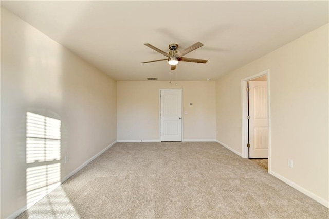 unfurnished room featuring light carpet, a ceiling fan, visible vents, and baseboards