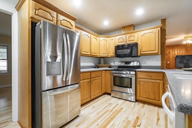 kitchen with appliances with stainless steel finishes, light hardwood / wood-style flooring, and ceiling fan