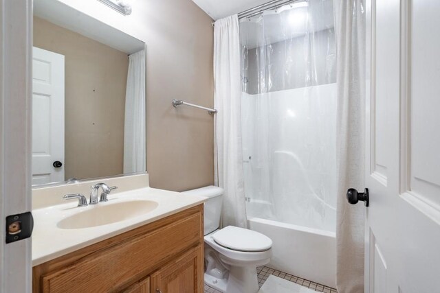 full bathroom featuring tile patterned floors, vanity, toilet, and shower / bath combo with shower curtain