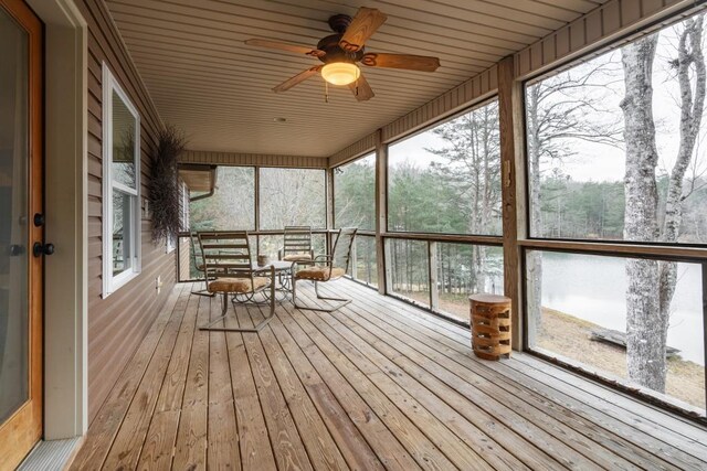 unfurnished sunroom with ceiling fan