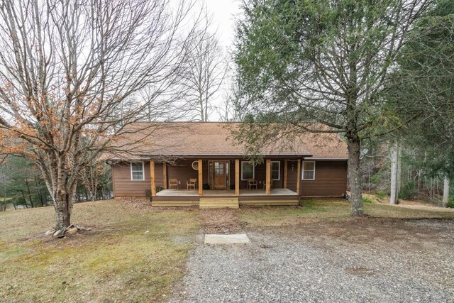 ranch-style house featuring covered porch and a front lawn