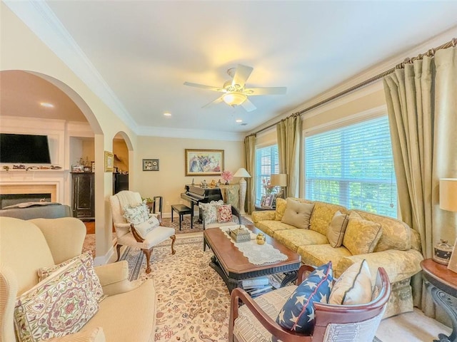 6416 Hickory Springs Cir, Hoschton, GA 30548 - living room featuring arched walkways, ornamental molding, ceiling fan, and a fireplace