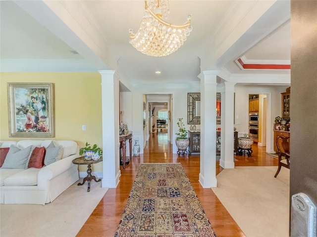6416 Hickory Springs Cir, Hoschton, GA 30548 - entrance foyer featuring ornate columns, crown molding, a chandelier, and light wood finished floors