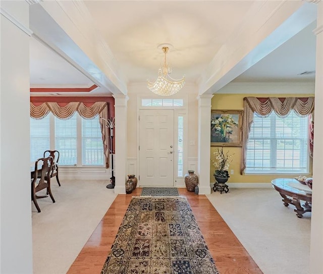 6416 Hickory Springs Cir, Hoschton, GA 30548 - foyer entrance with crown molding, a chandelier, wood finished floors, ornate columns, and baseboards