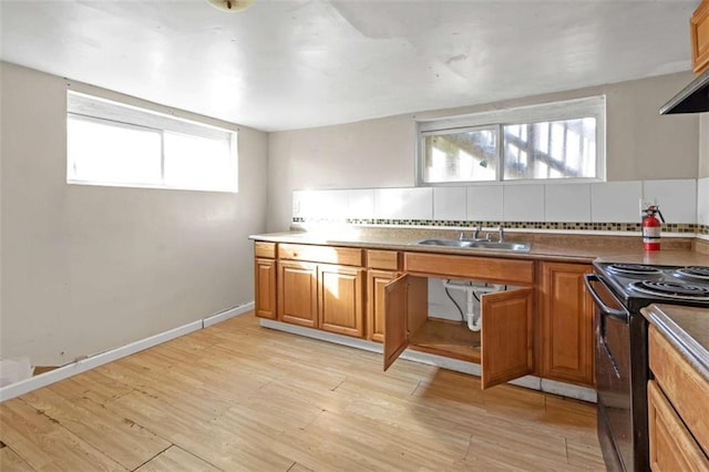 kitchen with exhaust hood, light hardwood / wood-style floors, sink, backsplash, and black electric range