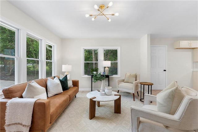 living room featuring light wood-type flooring, plenty of natural light, and a notable chandelier